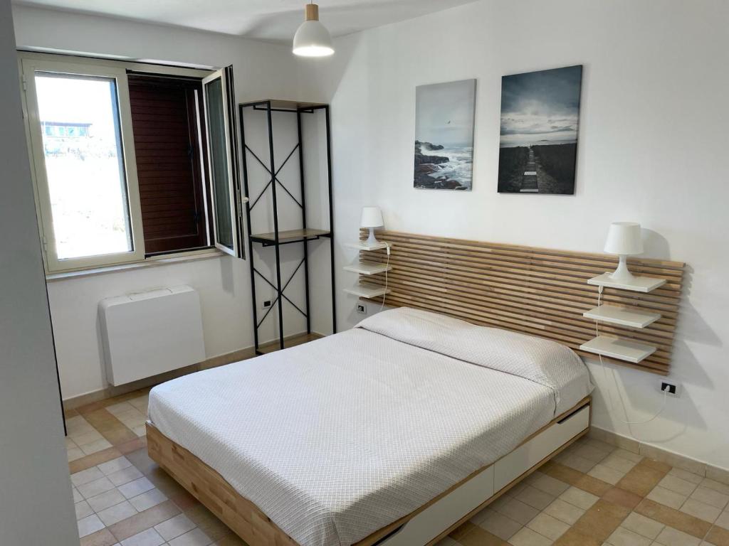 1 dormitorio con 1 cama, ventana y estanterías en Nella valle dei templi e sul mare, en Villaggio Mosè