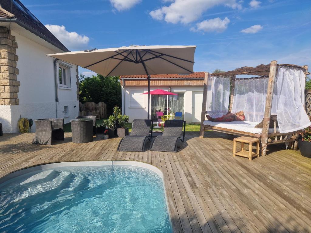 um quintal com uma piscina e um guarda-sol em La Balinaise Chambre indépendante avec jardin et piscine proche Chantilly, PARC ASTERIX et gare TER pour PARIS en 19min, à 15 min de Roissy CDG em Orry-la-Ville