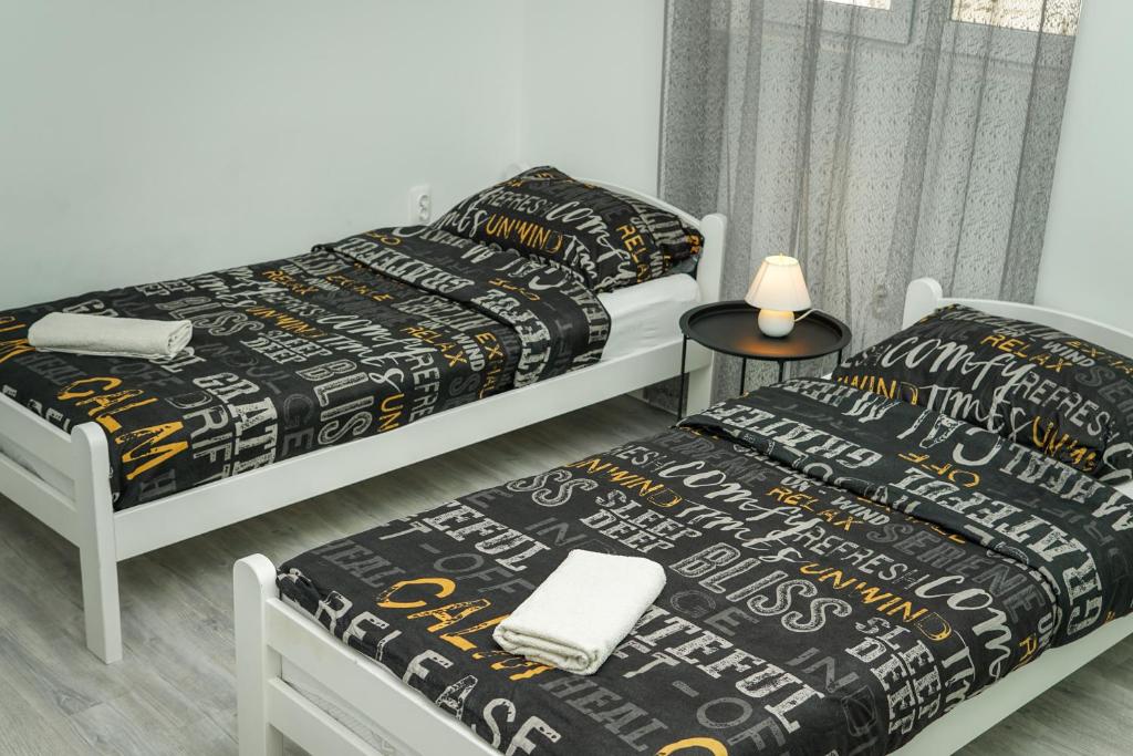 um quarto com 2 camas e uma mesa com um candeeiro em Studio ADA em Mostar