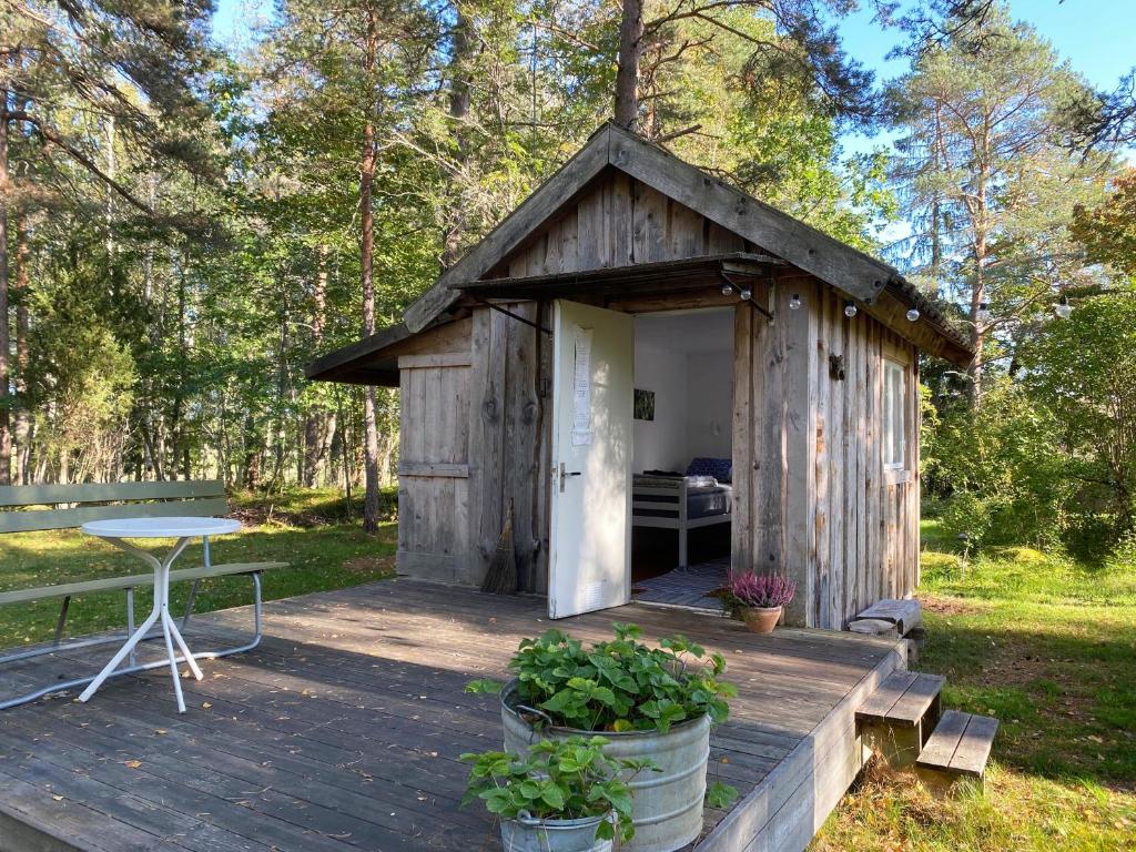 ein Holzhaus mit einem Tisch auf einer Terrasse in der Unterkunft Karlsäter - Lilla stugan in Älvkarleby