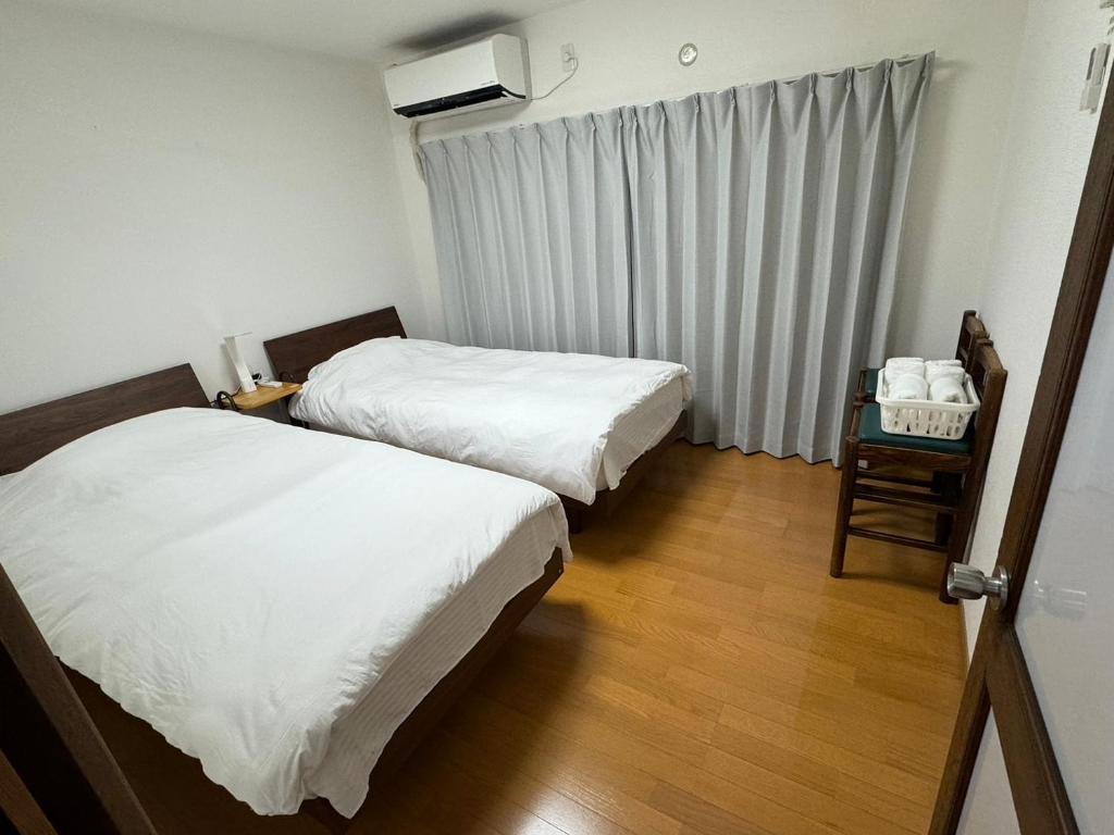 Habitación de hotel con 2 camas y ventana en Guesthouse Atelier Ten 民泊アトリエ天, en Osaka