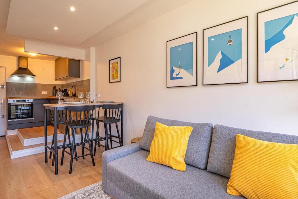 un salon avec un canapé et une cuisine dans l'établissement Chamois Blanc Rosières- bright 1 bed apartment with amazing views, à Chamonix-Mont-Blanc