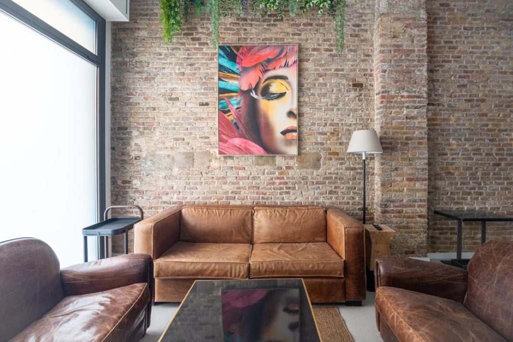 sala de estar con sofá y una pintura en una pared de ladrillo en Apartamento Barcelona centro, en Barcelona