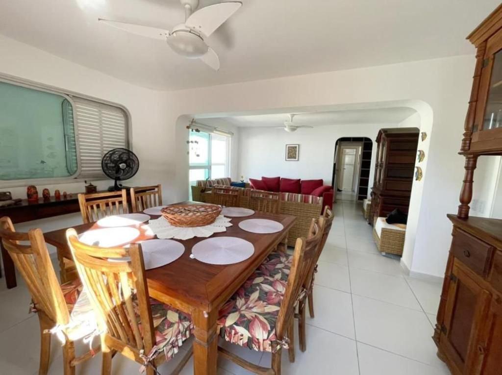 a dining room with a wooden table and chairs at AO SOM DO MAR - 15 metros da praia in Guarujá