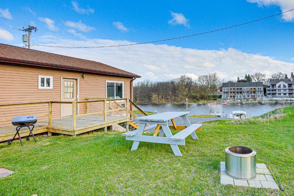 Centrally Located Michigan Cabin on Manistee River في مانيستي: طاولة نزهة على العشب بجوار منزل