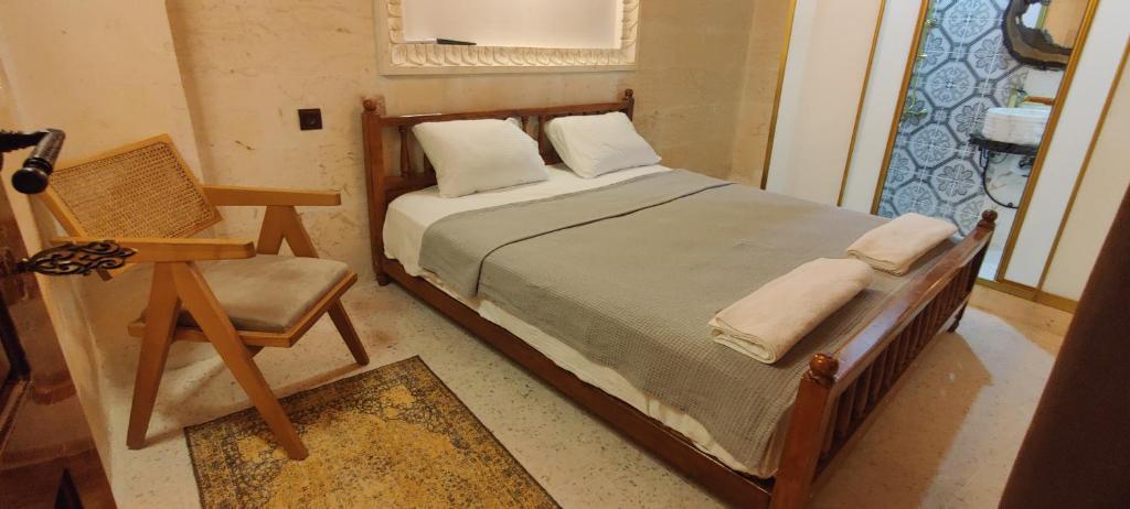 a bedroom with a bed and a chair and a window at Ktisis Butik Otel in Urfa
