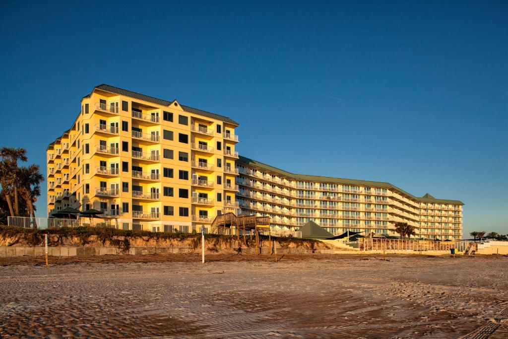 un gran edificio de apartamentos amarillo en la playa en Royal Floridian Resort South by Spinnaker en Ormond Beach