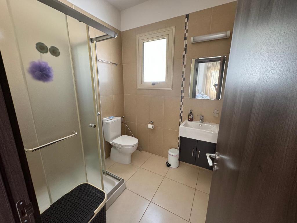 a bathroom with a shower and a toilet and a sink at Paez Villa in Protaras