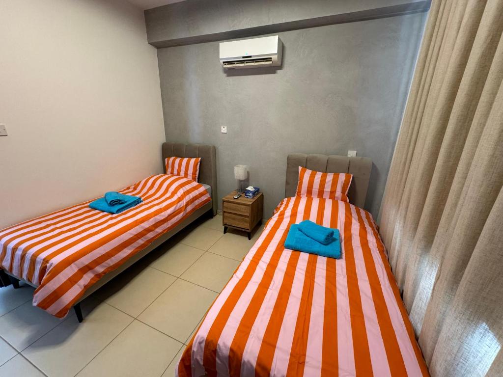 two beds in a room with blue towels on them at Paez Villa in Protaras