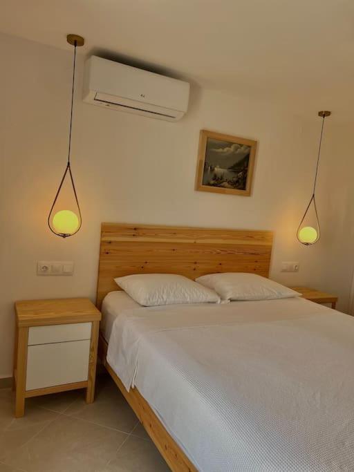 ein Schlafzimmer mit einem Bett mit zwei Lichtern an der Wand in der Unterkunft Sihena in Skiathos-Stadt