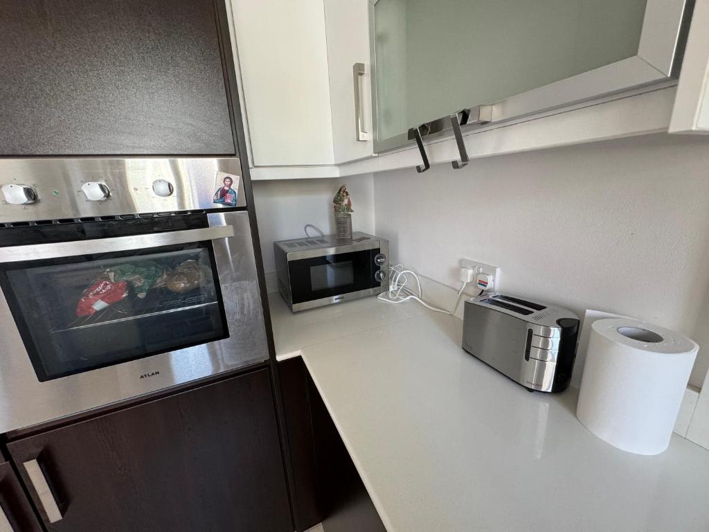 a small kitchen with a microwave and a counter top at Paez Villa in Protaras