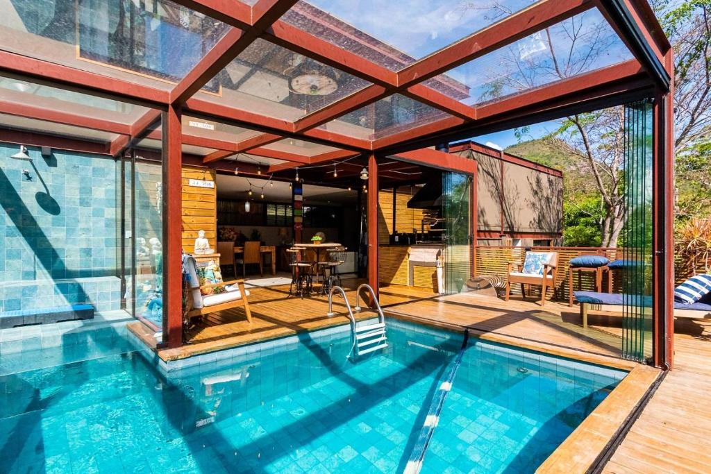a house with a swimming pool and a patio at Santa Serra Itaipava in Itaipava