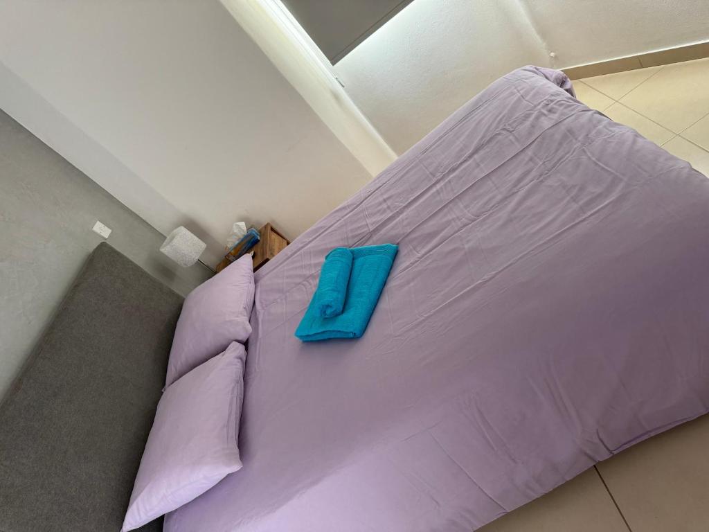 a purple bed with a blue pillow on it at Paez Villa in Protaras