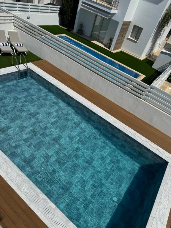 a swimming pool in the backyard of a house at Paez Villa in Protaras