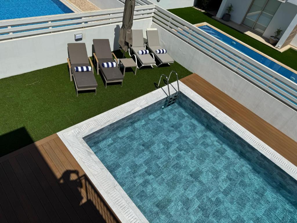 an overhead view of a swimming pool with chairs at Paez Villa in Protaras