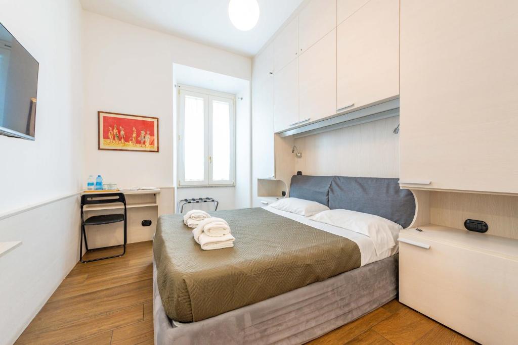 ein kleines Schlafzimmer mit einem Bett und einer Küche in der Unterkunft ANDENIS TIBER HOUSE in Rom