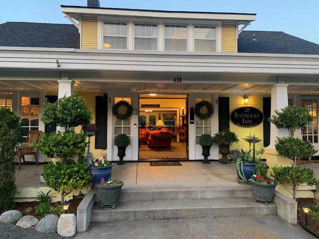 een veranda aan de voorzijde van een huis met planten in potten bij Bayberry Inn B&B and Oregon Wellness Retreat in Ashland