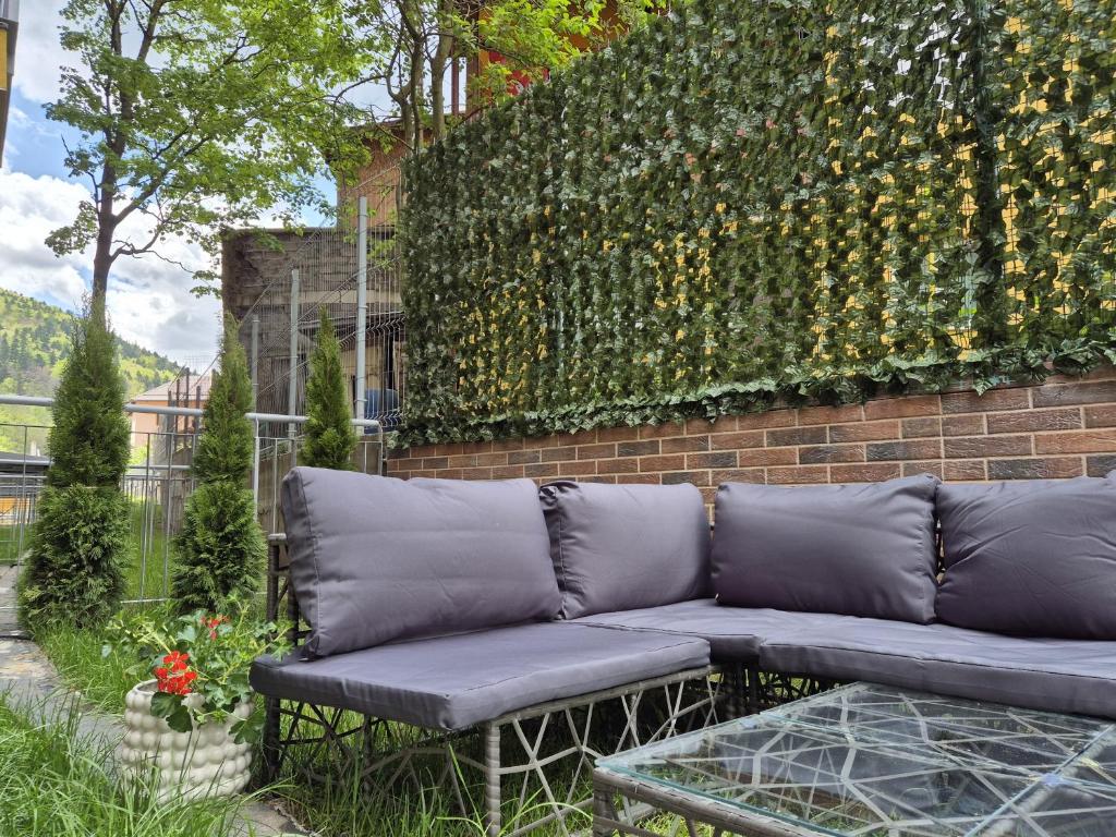 a couch sitting in front of a brick wall at Mountain View with Terrace in Sinaia