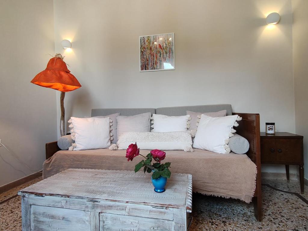 een woonkamer met een bank en een vaas met rozen op een tafel bij Mid century character house in Argostoli in Argostoli
