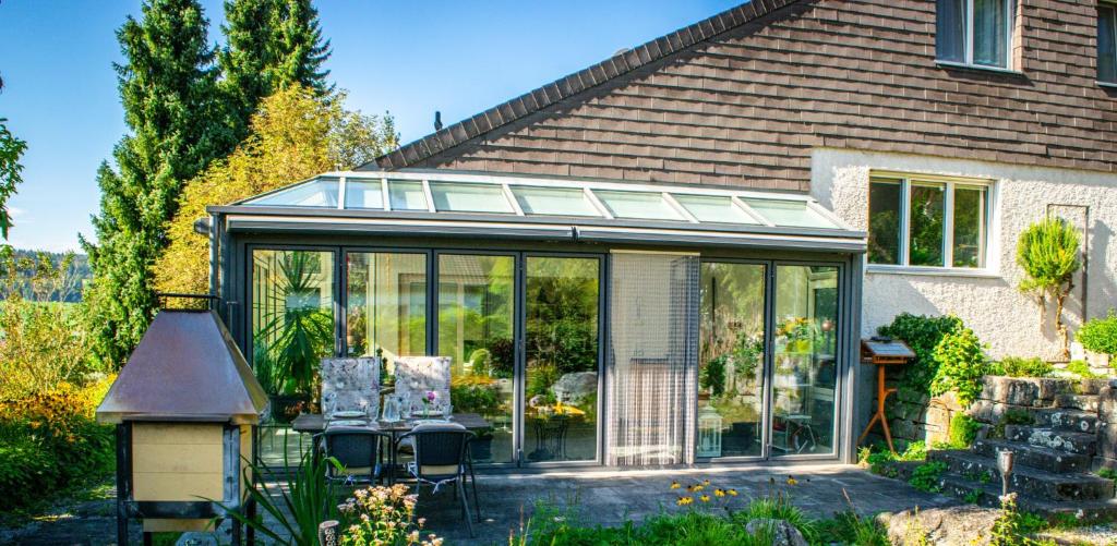 a house with a conservatory with glass doors at Waldparadies in Neftenbach I Winterthur Nummer 1 in Neftenbach