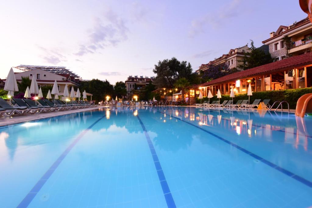 - une grande piscine d'eau bleue la nuit dans l'établissement Perdikia Hill Hotel And Villas, à Ölüdeniz