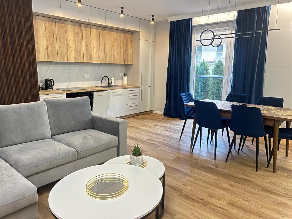 a living room with a couch and a table at Apartament Sosnowy przy Basenach Tropikalnych, prywatny parking in Kielce