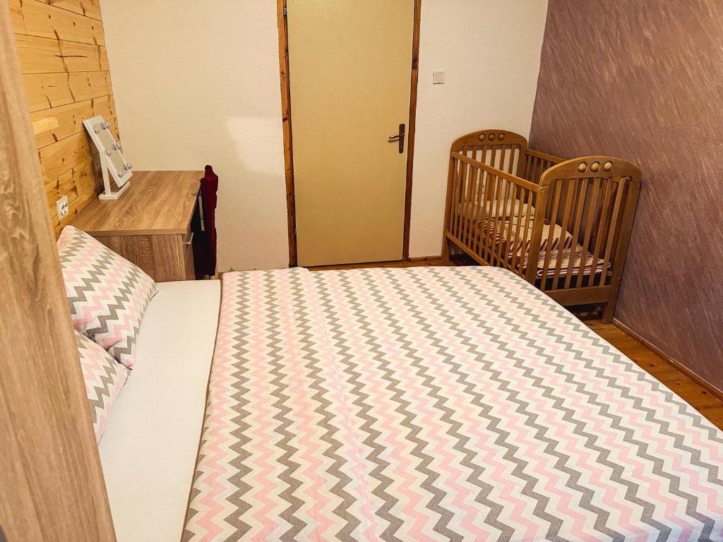 a bedroom with a bed and a crib and a crib at Apartman Olivera in Žabljak