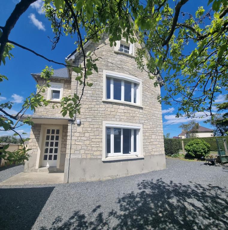 Cette grande maison en briques est dotée de fenêtres blanches. dans l'établissement Maison proche Omaha Beach, à Grandcamp-Maisy