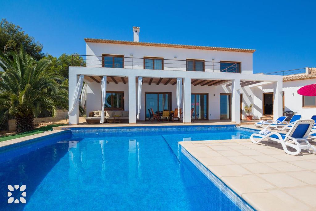 a villa with a swimming pool in front of a house at Villa Fustera by Abahana Villas in Benissa