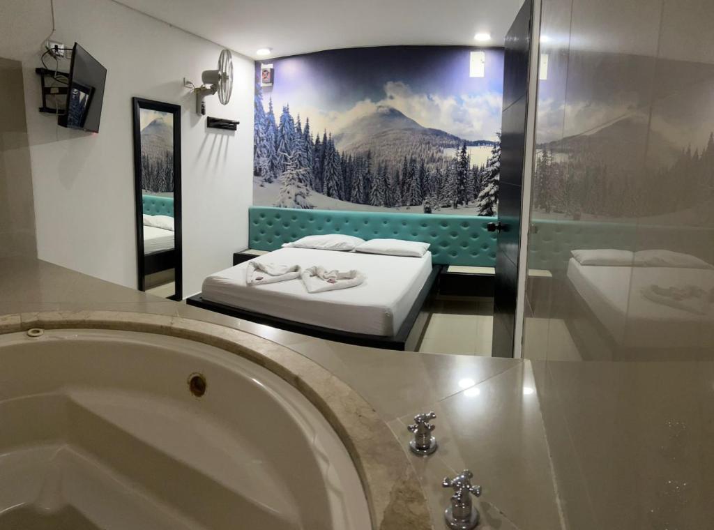 a bathroom with a tub and a bed and a mirror at Hotel Country Medellin in Medellín