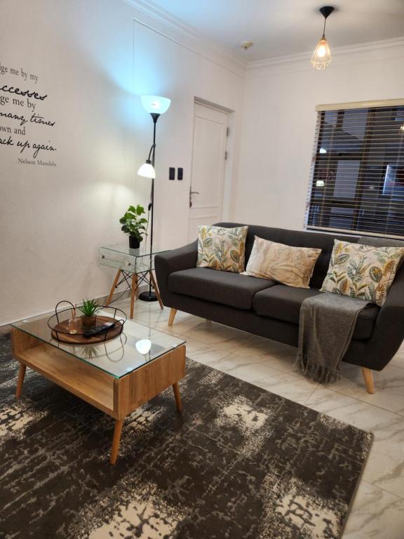 Sala de estar con sofá negro y mesa de centro en Chill On Gray en Johannesburgo