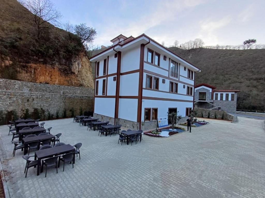 um grande edifício com mesas e cadeiras num pátio em ÇARDAK ALTI OTEL em Trabzon