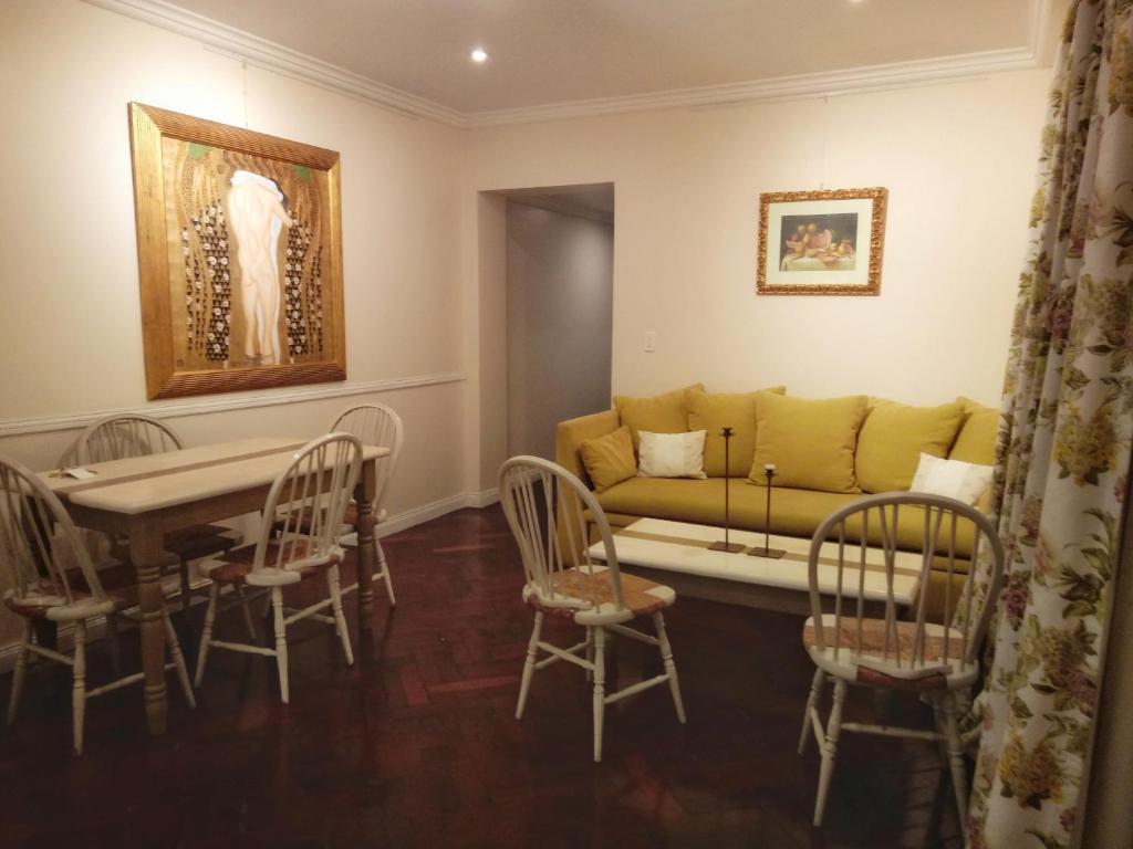 Moreno 820 Design Apartments في بوينس آيرس: غرفة معيشة مع أريكة وطاولة وكراسي