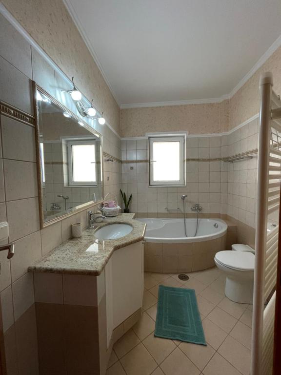 een badkamer met een bad, een wastafel en een toilet bij My Paradise in Asíni
