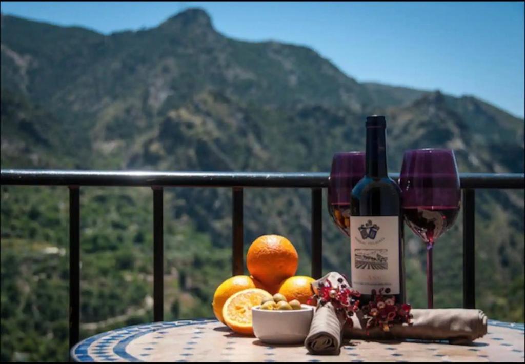 a table with a bottle of wine and some oranges at Apartamento Kariba Antigua Casa Anita in Güéjar-Sierra