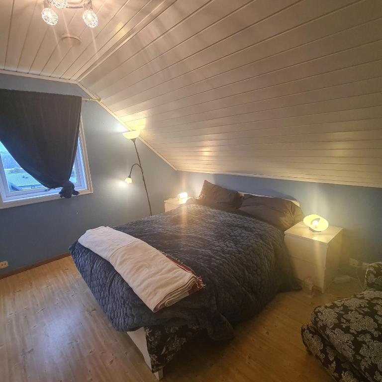 1 dormitorio con 1 cama, 2 lámparas y ventana en GG overnatting en Stavanger