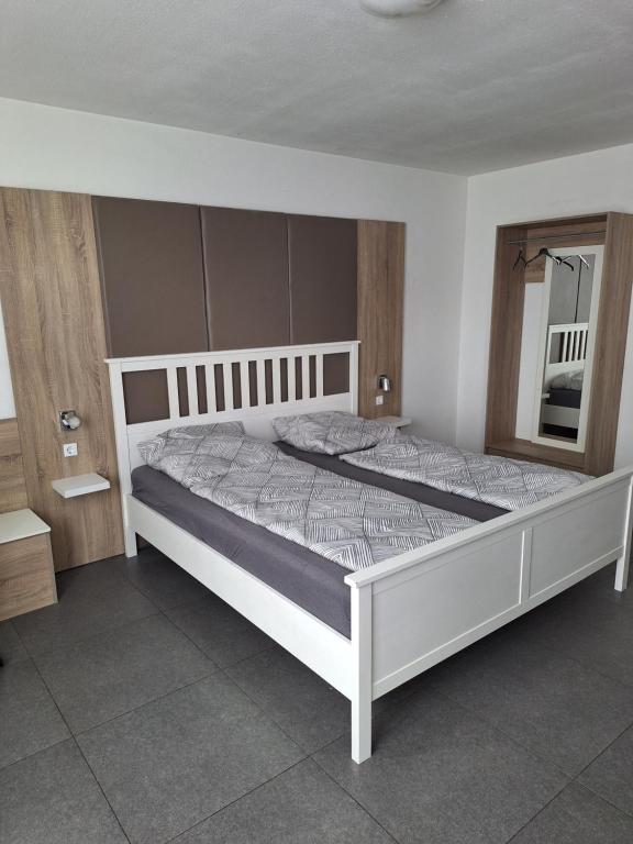 ein Schlafzimmer mit einem großen Bett mit einem weißen Rahmen in der Unterkunft modern Hoteliving Gießen in Gießen