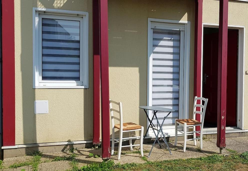 deux chaises et une table devant un bâtiment dans l'établissement Joli studio près de la mer avec extérieur, à La Rochelle