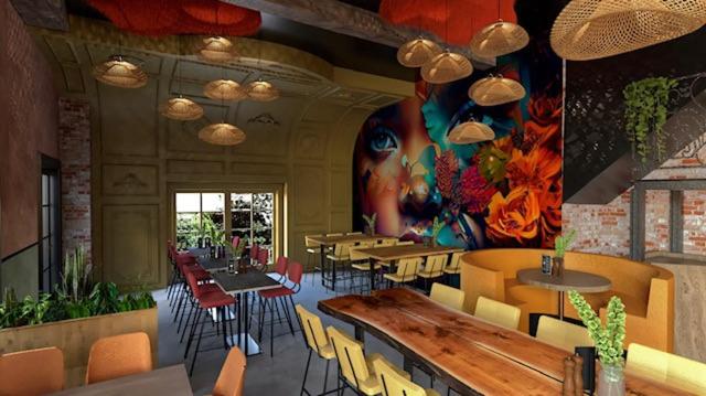 格羅寧根的住宿－PJs Hostel，餐厅设有桌椅,墙上挂有绘画作品