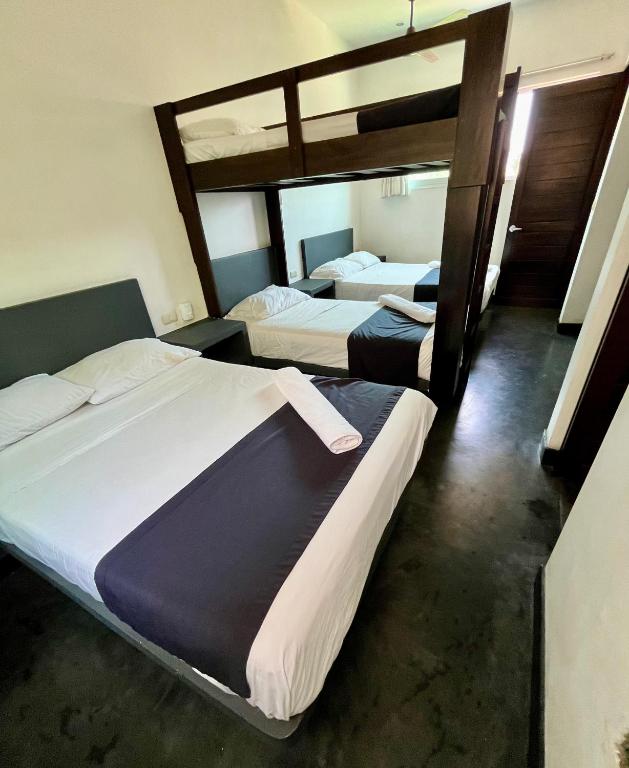 two beds in a room with two beds sidx sidx sidx at Hotel Aqualuna Departamento #aussiepipe in Puerto Escondido