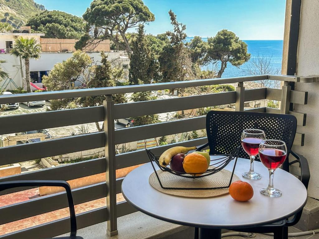 a table with a bowl of fruit and two glasses of wine at Currilave 664 in Durrës