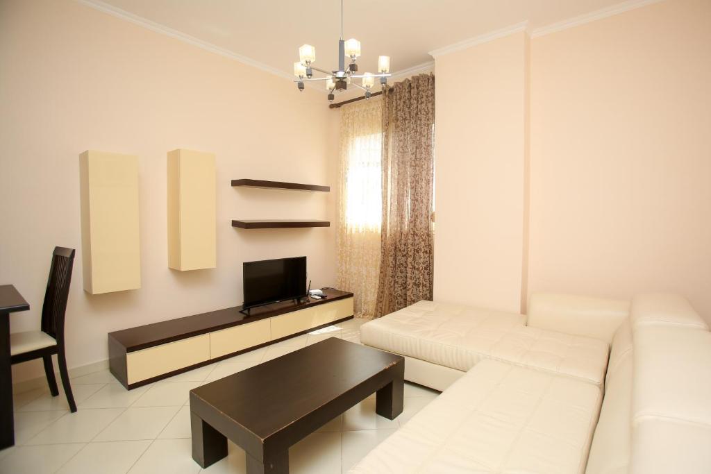 een woonkamer met een witte bank en een tafel bij FM Apartments 2 in Vlorë