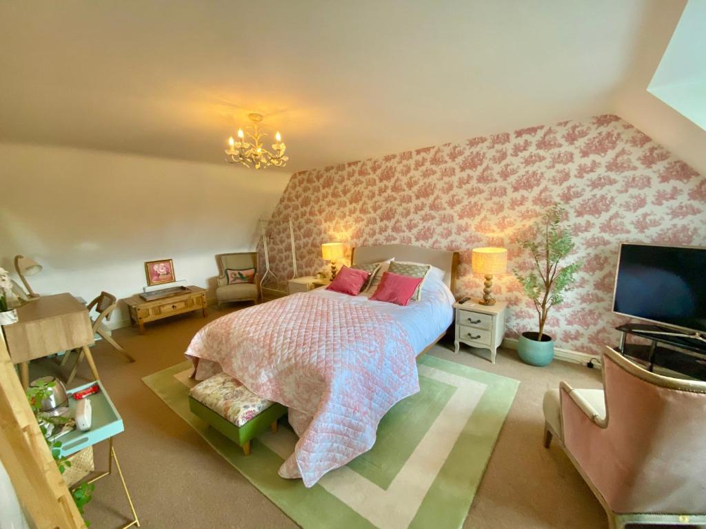 ein Schlafzimmer mit einem großen Bett und einem TV in der Unterkunft Number 2, Spacious Rooms, Near Ironbridge! in Telford