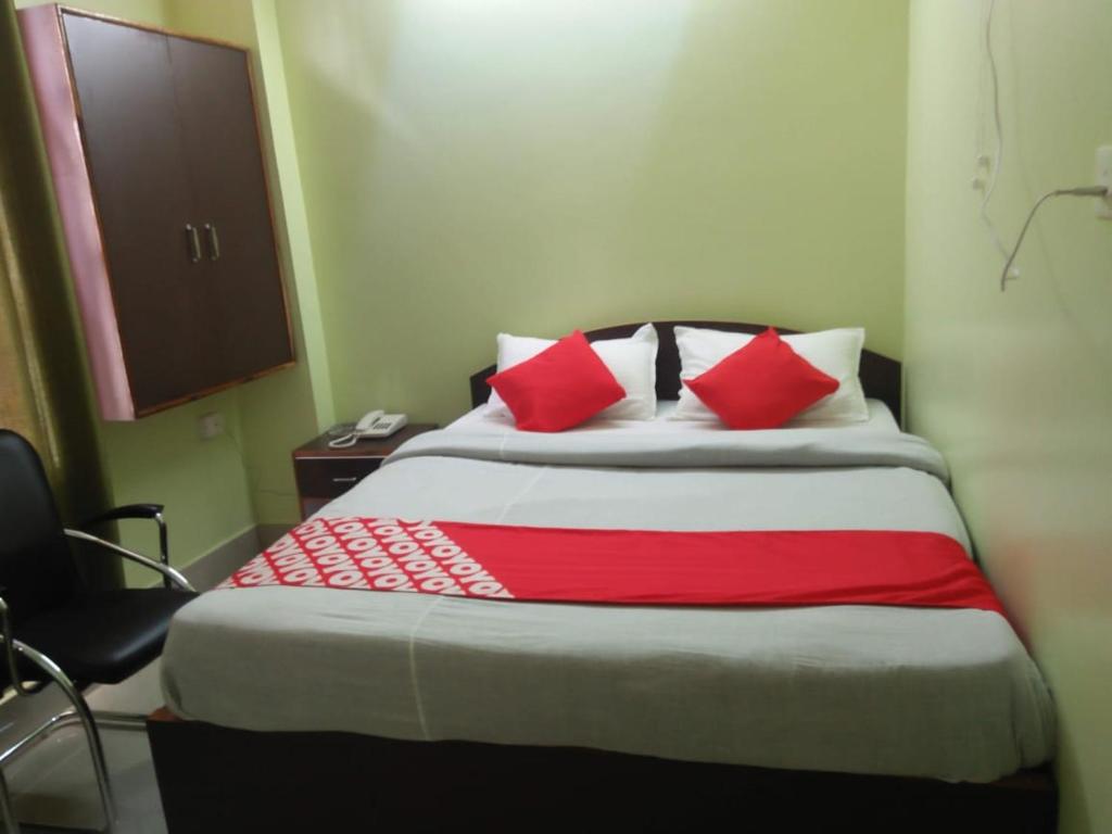 Una cama en una habitación con almohadas rojas. en Field Residency Inn, en Shillong