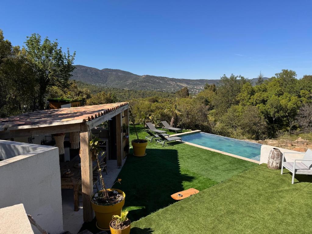 une cour arrière avec une piscine et une maison dans l'établissement La forêt, au Plan-de-la-Tour