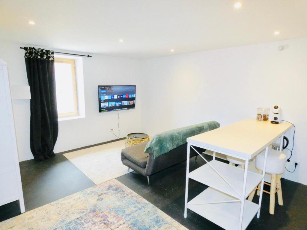 ein Wohnzimmer mit einem Sofa und einem Tisch in der Unterkunft Studio St Julien near Geneva in Saint-Julien-en-Genevois