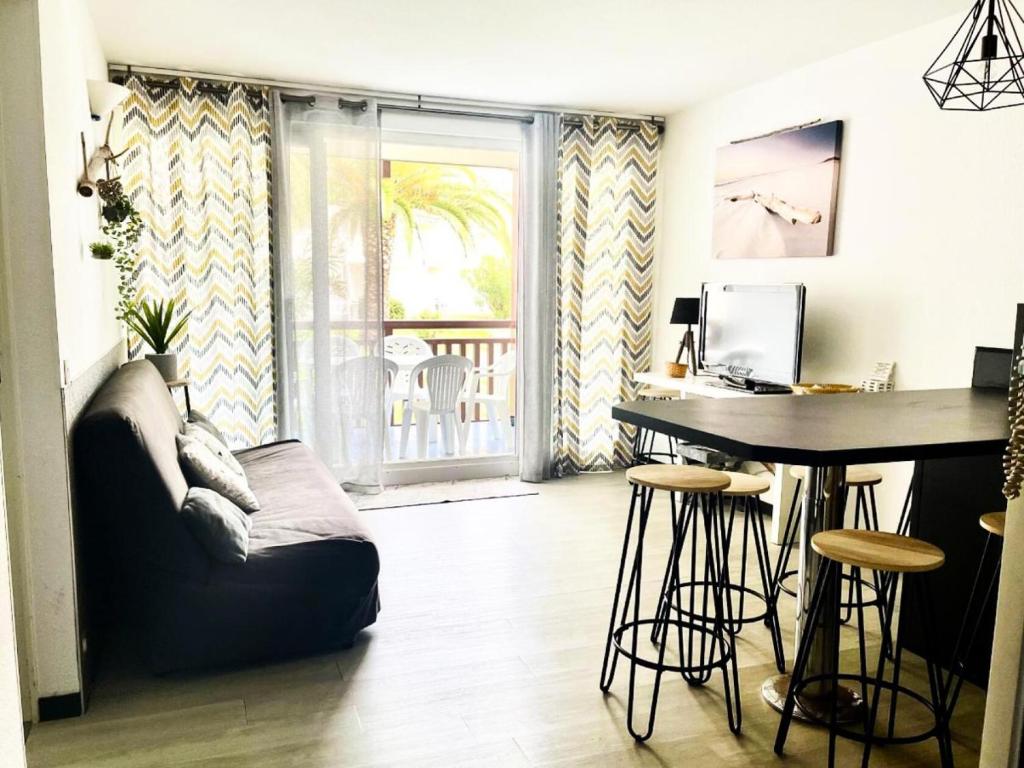 un salon avec une table et un canapé dans l'établissement Résidence Le Boucanier - 2 Pièces pour 6 Personnes 694, à Vieux-Boucau-les-Bains