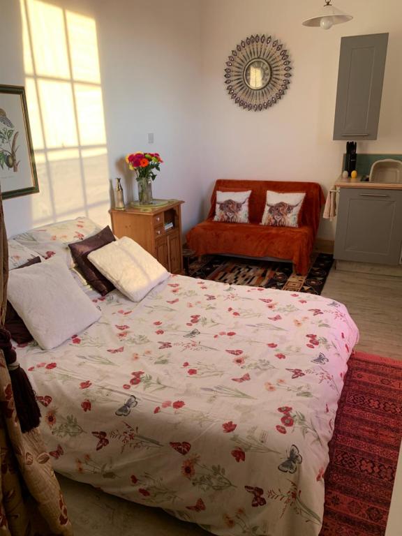 a bedroom with a bed and a couch at Norfolk broads. Vault apartment in Stalham
