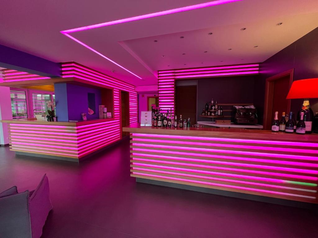 a bar with purple lighting in a room at Eco Hotel Cleofe in Caorle