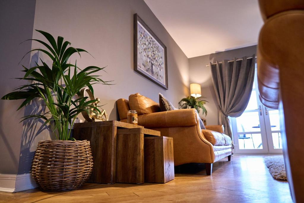 a living room with a couch and a plant at 6 Mariners Point in Hartlepool